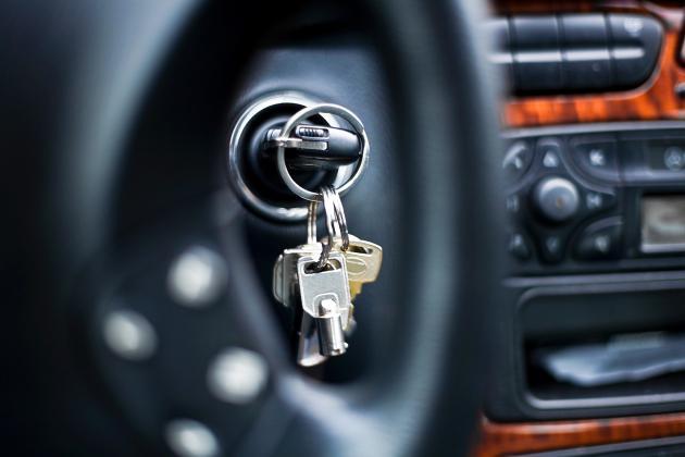 A closeup of a key ring inside of a vehicle, with one of the keys inserted into the ignition switch.