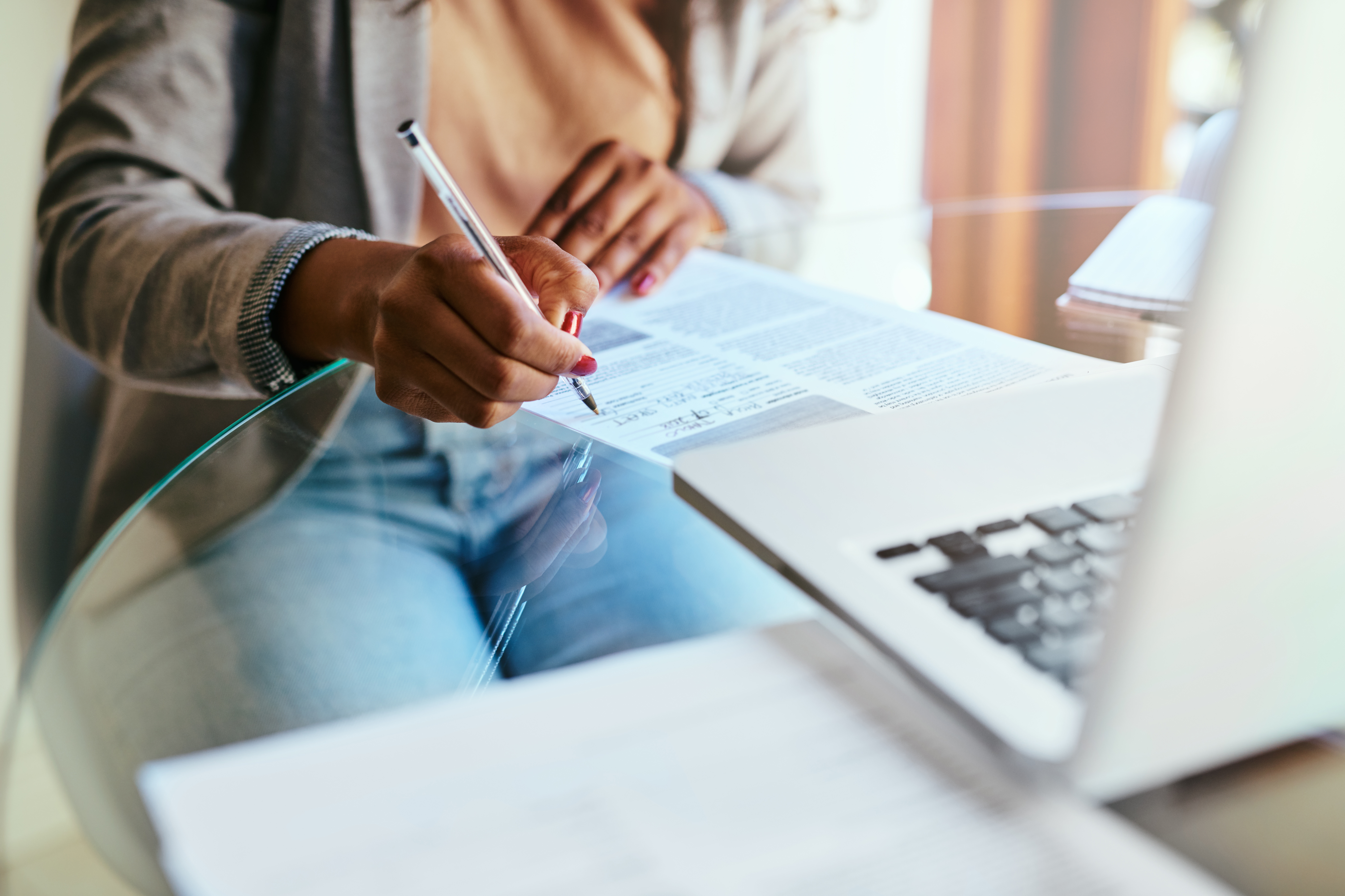 Woman filling out form on computer and paper