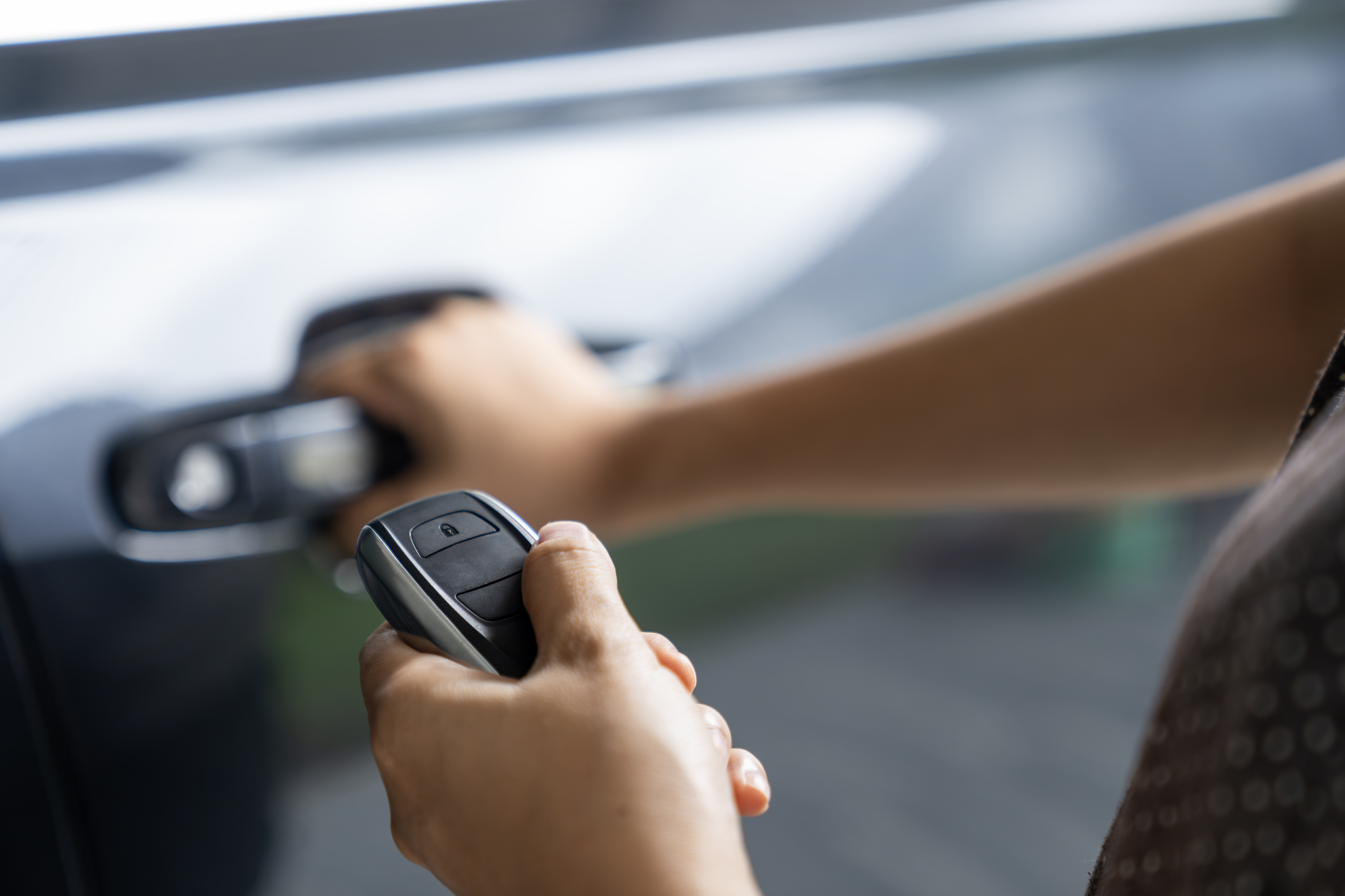 Woman holding car FOB and door handle